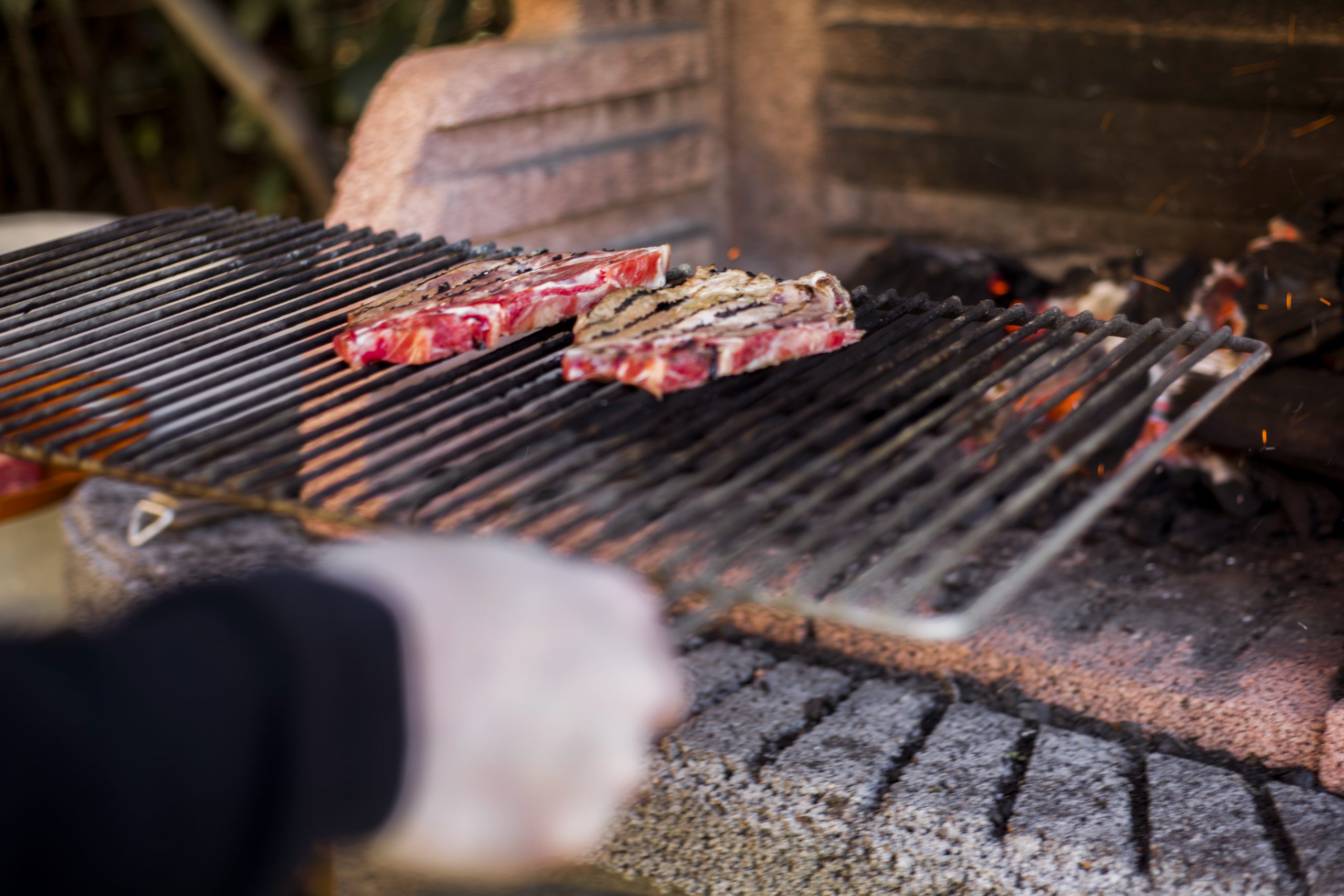 person-preparing-grilled-beef-barbecue